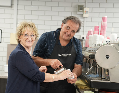 Trainer with student making coffee in cafe